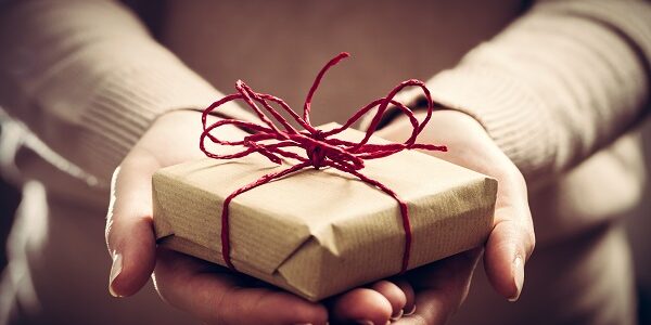Giving a gift, handmade present wrapped in paper gift giving